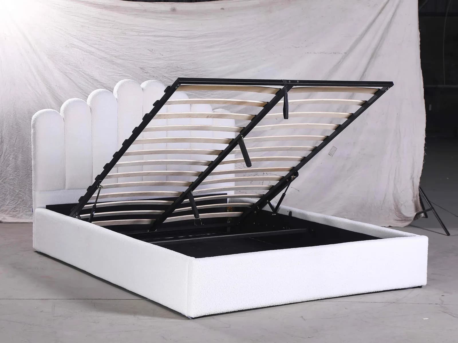 Upholstered storage bed with the lift-up base open, photographed for client product listings